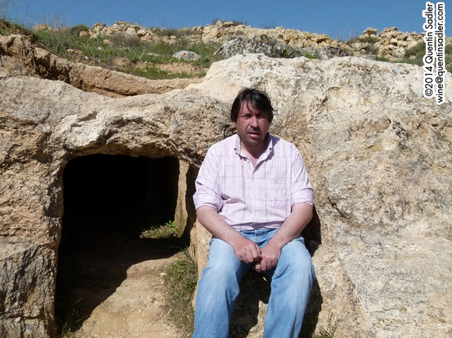 Fabrice sitting on the mourner's seat carved into the rock of the ancient tomb.